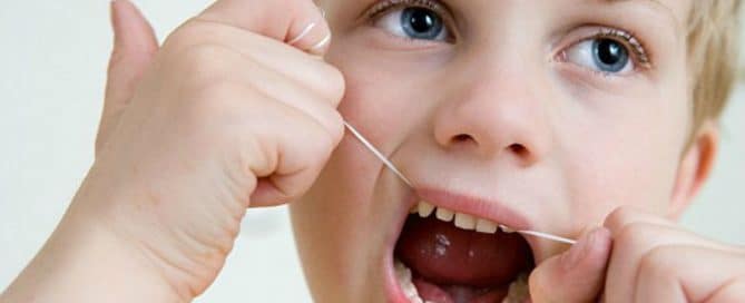 Boy flossing his teeth
