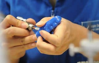 Dentist custom making a blue mouthguard